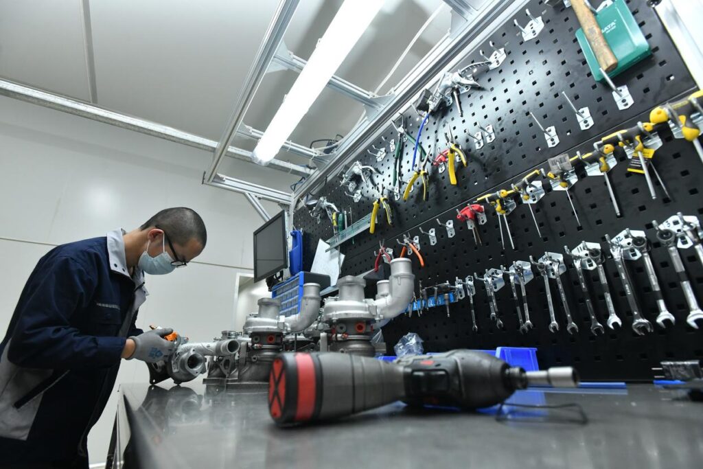 Technician working on turbochargers at an equipped workshop bench